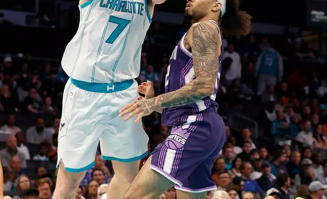 Charlotte Hornets guard Kon Knueppel (7) drives to the basket against Sacramento Kings guard Devin Carter during the first half of an NBA basketball game in Charlotte, N.C., Tuesday, March 24, 2026. (AP Photo/Nell Redmond)