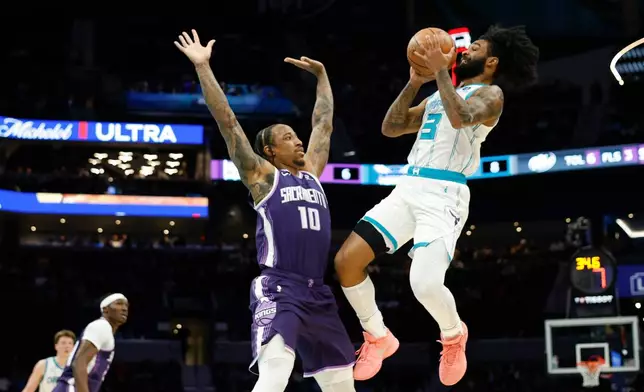 Charlotte Hornets guard Coby White (3) looks to shoot against Sacramento Kings guard DeMar DeRozan (3) during the first half of an NBA basketball game in Charlotte, N.C., Tuesday, March 24, 2026. (AP Photo/Nell Redmond)