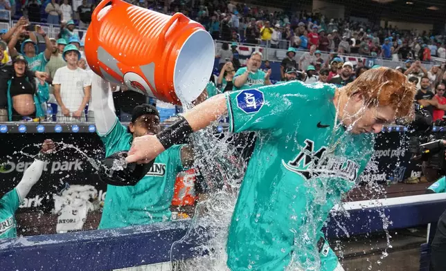 Miami Marlins' Owen Caissie, right, is doused after scoring on a walk-off two run home run to defeat the Colorado Rockies in a baseball game, Sunday, March 29, 2026, in Miami. (AP Photo/Lynne Sladky)