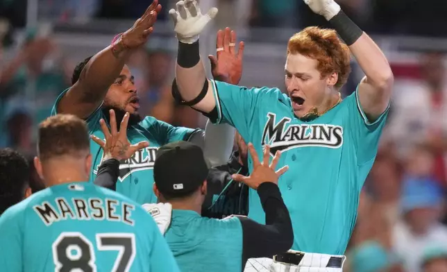 Miami Marlins' Owen Caissie, right, reacts after scoring on a walk-off two run home run to defeat the Colorado Rockies in a baseball game, Sunday, March 29, 2026, in Miami. (AP Photo/Lynne Sladky)