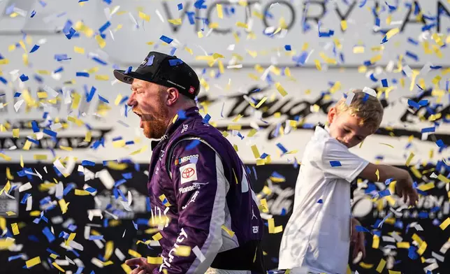 Tyler Reddick, left, celebrates with his son Beau, right, in Victory Lane after winning a NASCAR Cup Series auto race, Sunday, March 22, 2026, in Darlington, S.C.(AP Photo/Matt Kelley)