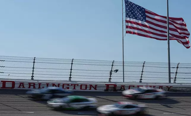 A pack of cars compete through Turn 3 during a NASCAR Cup Series auto race, Sunday, March 22, 2026, in Darlington, S.C.(AP Photo/Matt Kelley)