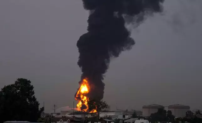 Fire and plumes of smoke rises after a drone struck a fuel tank forcing the temporary suspension of flights. near Dubai International Airport, in United Arab Emirates, early Monday, March 16, 2026. (AP Photo)
