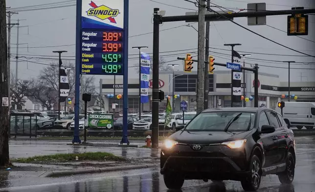 A car drives by a gas station with fuel prices displayed in Parma, Ohio, Thursday, March 26, 2026. (AP Photo/Sue Ogrocki)