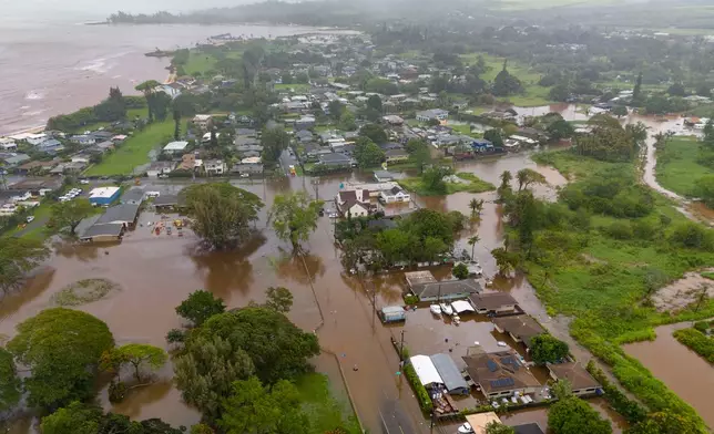 Streets are flooded from severe rains, Friday, March 20, 2026, in Haleiwa, Hawaii. (AP Photo/Mengshin Lin)