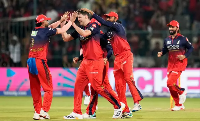 Royal Challengers Bengaluru's Jacob Duffy, second left, celebrates with teammates the wicket of Sunrisers Hyderabad's Travis Head during the Indian Premier League cricket match between Royal Challengers Bengaluru and Sunrisers Hyderabad in Bengaluru, India, Saturday, March 28, 2026. (AP Photo/Aijaz Rahi)