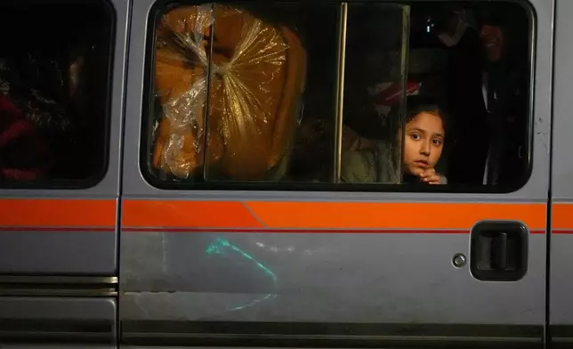 A girl sits in a van as displaced families fleeing Israeli strikes in southern Lebanon arrive in the southern port city of Sidon, early Monday, March 2, 2026. (AP Photo/Mohammed Zaatari)