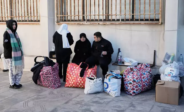 A displaced family who fled Israeli airstrikes in southern Lebanon sits at a school turned into a shelter, in Beirut, Lebanon, Monday, March 2, 2026. (AP Photo/Bilal Hussein)