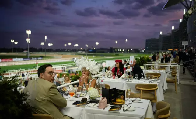 Racegoers dine at in the grandstand during the Dubai World Cup at Meydan Racecourse in Dubai, United Arab Emirates, Saturday, March 28, 2026. (AP Photo/Altaf Qadri)