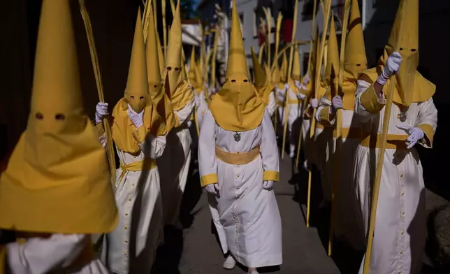 Penitents of the "Pollinita" brotherhodod take part in a Holy Week procession in Cabra, southern Spain, Sunday, March 29, 2026. (AP Photo/Manu Fernandez)