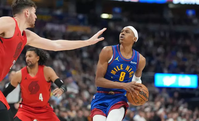 Denver Nuggets guard Peyton Watson, right, drives to the rim as Portland Trail Blazers center Donovan Clingan defends in the second half of an NBA basketball game Sunday, March 22, 2026, in Denver. (AP Photo/David Zalubowski)