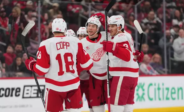 iDetroit Red Wings' Moritz Seider, center, celebrates with teamates after scoring a goal during the first period of an NHL hockey game against the New Jersey Devils Sunday, March 8, 2026, in Newark, N.J. (AP Photo/Frank Franklin II)