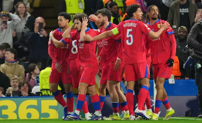 Paris Saint-Germain players celebrate after PSG's Bradley Barcola scored his side's second goal during the Champions League soccer match between Chelsea and Paris Saint-Germain in London, England, Tuesday, March 17, 2026. (AP Photo/Kin Cheung)