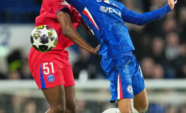 PSG's Willian Pacho, left, challenges for the ball with Chelsea's Joao Pedro during the Champions League soccer match between Chelsea and Paris Saint-Germain in London, England, Tuesday, March 17, 2026. (AP Photo/Kin Cheung)