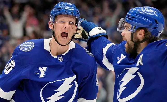 Tampa Bay Lightning right wing Corey Perry (10) celebrates his goal against the Seattle Kraken with center Brayden Point (21) during the second period of an NHL hockey game Thursday, March 26, 2026, in Tampa, Fla. (AP Photo/Chris O'Meara)