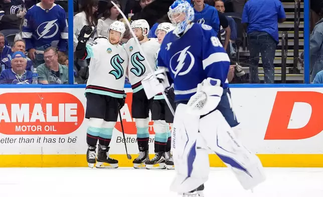 Seattle Kraken defenseman Brandon Montour, right, celebrates after scoring against Tampa Bay Lightning goaltender Andrei Vasilevskiy (88) during overtime of an NHL hockey game Thursday, March 26, 2026, in Tampa, Fla. (AP Photo/Chris O'Meara)