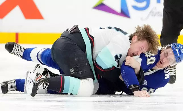 Seattle Kraken center Berkly Catton (27) and Tampa Bay Lightning defenseman J.J. Moser (90) go down while fighting during the second period of an NHL hockey game Thursday, March 26, 2026, in Tampa, Fla. (AP Photo/Chris O'Meara)