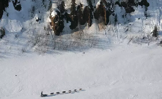FILE - Ryan Redington of Knik, Alaska, grandson of Joe Redington Sr., the father of the Iditarod, drives his team on the Yukon River past the bluffs near Grayling, Alaska, on the Iditarod Trail Sled Dog Race, March 10, 2007. (AP Photo/Al Grillo)