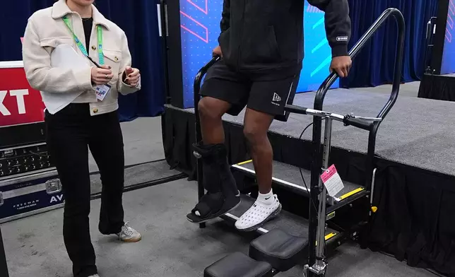 Penn State running back Nicholas Singleton walks with a boot down steps after speaking during a news conference at the NFL football scouting combine in Indianapolis, Friday, Feb. 27, 2026. (AP Photo/Julio Cortez)