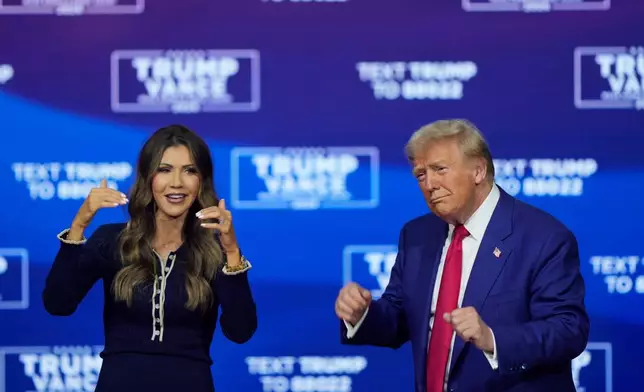 FILE - Republican presidential nominee former President Donald Trump and South Dakota Gov. Kristi Noem dance to the song "Y.M.C.A." at a campaign town hall at the Greater Philadelphia Expo Center &amp; Fairgrounds, Oct. 14, 2024, in Oaks, Pa. (AP Photo/Matt Rourke, File)