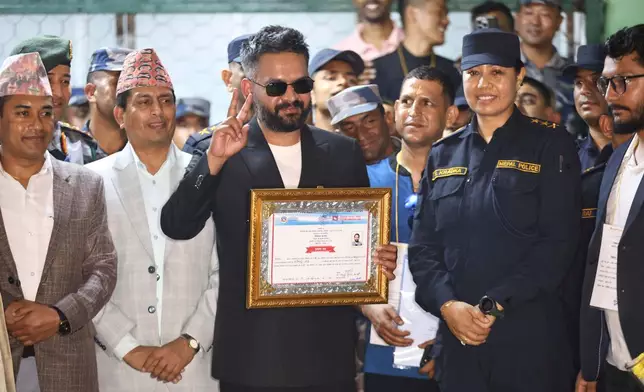 Balendra Shah, foreground, former mayor of Kathmandu Metropolitan City and prime ministerial candidate of the Rastriya Swatantra Party, receives his victory certificate after defeating former Prime Minister Khadga Prasad Oli of the Communist Party of Nepal–Unified Marxist-Leninist (CPN-UML) in Jhapa, about 267 miles (430 kilometers) southeast of Kathmandu, Nepal, Sunday, March 8, 2026. (AP Photo/Umesh Karki)