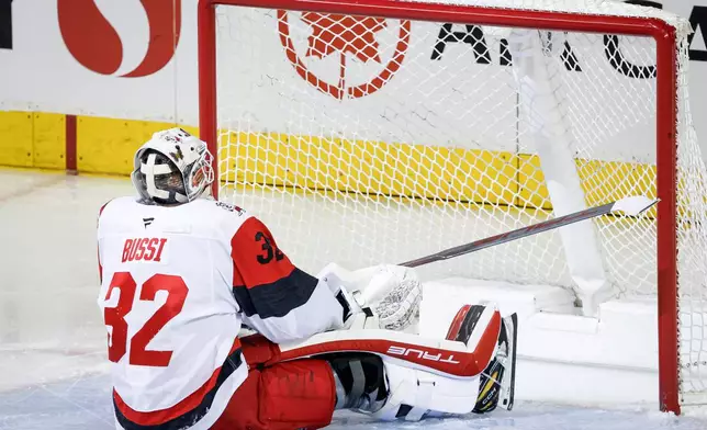 Carolina Hurricanes goalie Brandon Bussi reacts after letting in a goal during second period NHL hockey action against the Calgary Flames in Calgary on Saturday, March 7, 2026. (Jeff McIntosh/The Canadian Press via AP)
