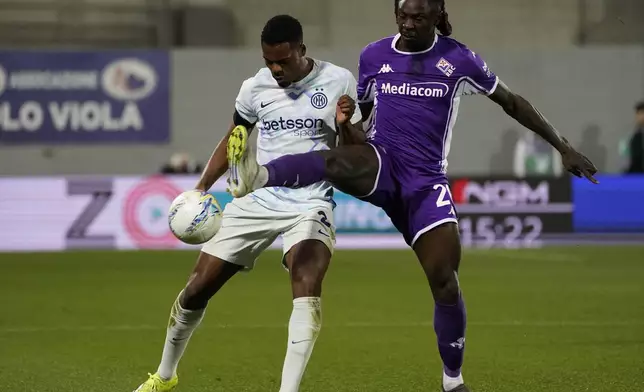 Inter's Denzel Dumfries, left, and Fiorentina's Moise Kean, right, challenge for the ball during the Serie A soccer match between Fiorentina and Inter Milan in Florence, Italy, Sunday, March 22, 2026. (Marco Bucco/LaPresse via AP)