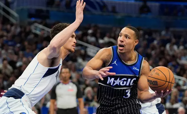 Orlando Magic guard Desmond Bane (3) drives to the basket against Dallas Mavericks forward Dwight Powell, left, during the second half of an NBA basketball game, Thursday, March 5, 2026, in Orlando, Fla. (AP Photo/John Raoux)