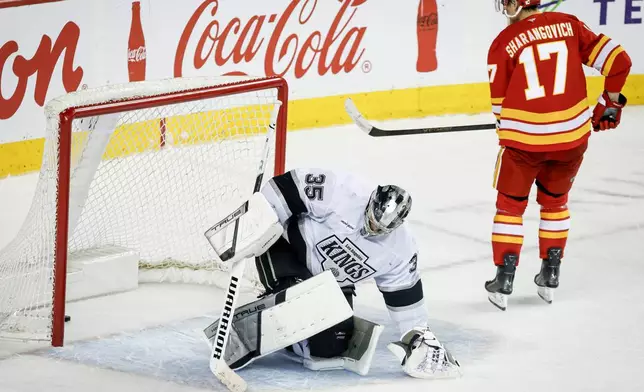 Los Angeles Kings goalie Darcy Kuemper, left, reacts after Calgary Flames' Yegor Sharangovich scored the winning shootout goal during overtime of an NHL hockey game in Calgary on Tuesday, March 24, 2026. (Jeff McIntosh/The Canadian Press via AP)