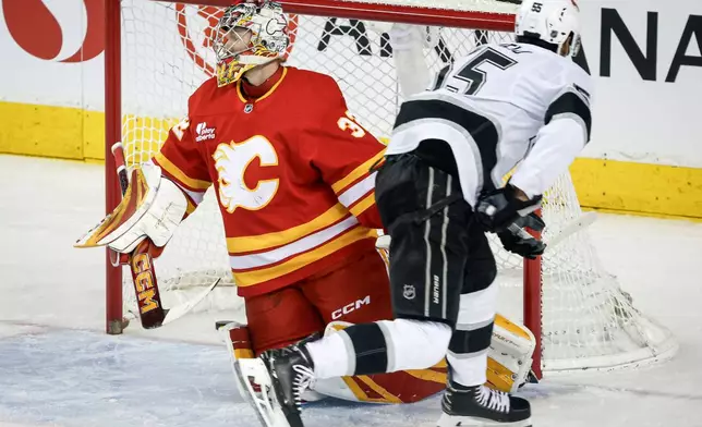Los Angeles Kings' Quinton Byfield, right, skates away after scoring on Calgary Flames goalie Dustin Wolf during the first period of an NHL hockey game in Calgary on Tuesday, March 24, 2026. (Jeff McIntosh/The Canadian Press via AP)