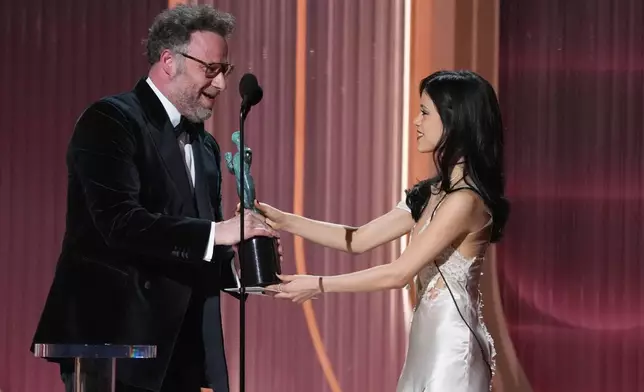 Jenna Ortega, right, presents the award for outstanding performance by a male actor in a comedy series to Seth Rogen, left, for "The Studio" during the 32nd Annual Actor Awards on Sunday, March 1, 2026, at the Shrine Auditorium and Expo Hall in Los Angeles. (AP Photo/Chris Pizzello)
