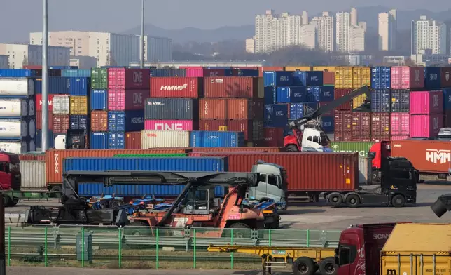 Turcks run by containers at the Uiwang ICD Terminal in Uiwang, South Korea, Thursday, March 12, 2026. (AP Photo/Ahn Young-joon)