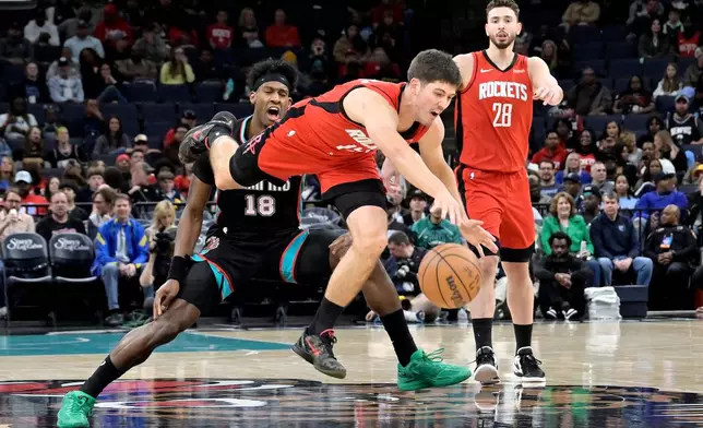 Houston Rockets guard Reed Sheppard, center, dives for the ball ahead of Memphis Grizzlies forward Olivier-Maxence Prosper (18) and center Alperen Sengun (28) in the first half of an NBA basketball game Friday, March 27, 2026, in Memphis, Tenn. (AP Photo/Brandon Dill)