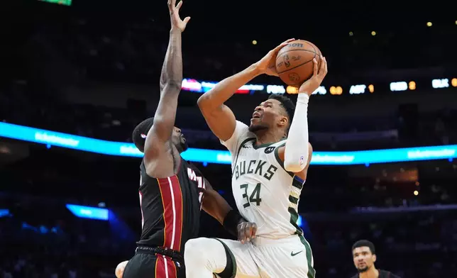 Milwaukee Bucks forward Giannis Antetokounmpo (34) drives to the basket as Miami Heat center Bam Adebayo defends during the first half of an NBA basketball game Thursday, March 12, 2026, in Miami. (AP Photo/Marta Lavandier)