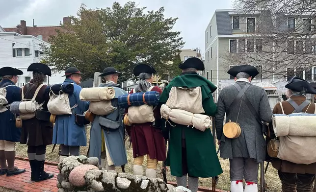 Revolutionary War reenactors line up outside St. Augustine Chapel and Cemetery in South Boston, Tuesday, March 17, 2026, before firing muskets during Evacuation Day commemorations marking the 250th anniversary of the British withdrawal from Boston. (AP Photo/Leah Willingham)
