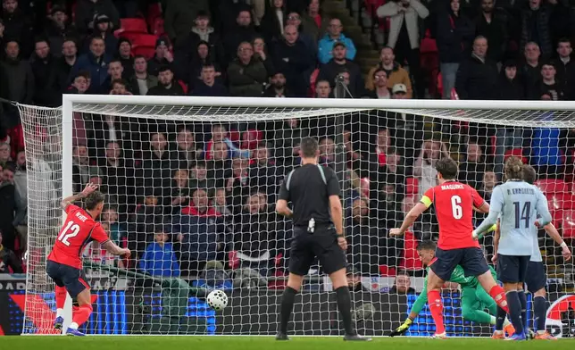 England's Ben White, left, scores his side's opening goal during the international friendly soccer match between England and Uruguay in London, Friday, March 27, 2026. (AP Photo/Alastair Grant)