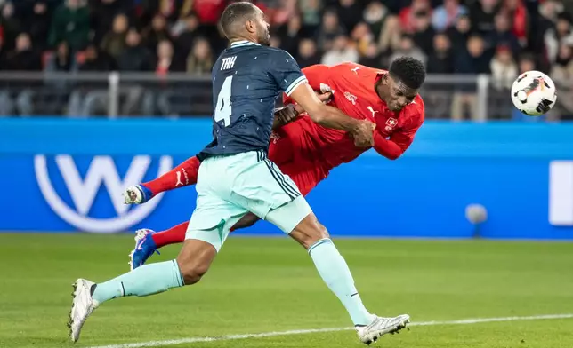 Switzerland's Breel Embolo, right, scores the second goal for Switzerland against Germany's Jonathan Tah, left, during an international friendly soccer match between Switzerland and Germany in Basel, Switzerland, Friday, March 27, 2026. (Claudio Thoma/Keystone via AP)