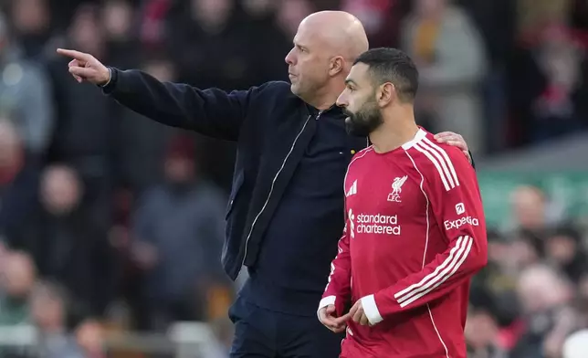 Liverpool's manager Arne Slot talks to Mohamed Salah during the Premier League soccer match between Liverpool and Tottenham in Liverpool, England, Sunday, March 15, 2026. (AP Photo/Jon Super)