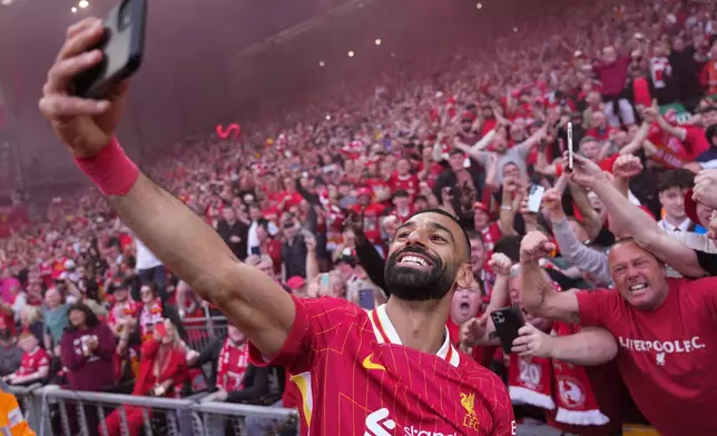FILE - Liverpool's Mohamed Salah celebrates by taking a selfie after winning the English Premier League soccer match between Liverpool and Tottenham Hotspur and clinching the Premier League title at Anfield in Liverpool, England, April 27, 2025. (AP Photo/Jon Super, File)