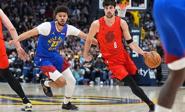 Portland Trail Blazers forward Deni Avdija (8) drives the lane as Denver Nuggets forward Cameron Johnson (23) defends in the first half of an NBA basketball game Sunday, March 22, 2026, in Denver. (AP Photo/David Zalubowski)