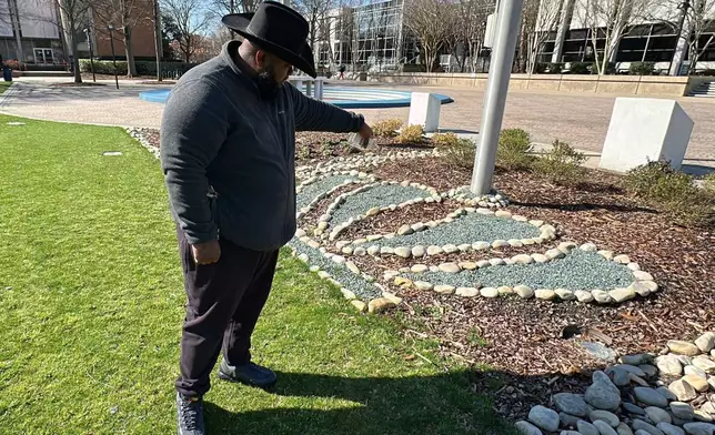 Eddie Flack pour out a bottle of whiskey at the base of the flagpoles in front of Constant Hall as he pays respect to slain Lt. Col. Brandon Shah at Old Dominion University on Friday, March 13, 2026 in Norfolk, Va. (AP Photo/Allen G. Breed)