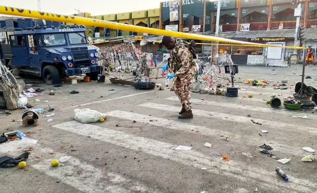 A soldier inspects the aftermath of Monday's bomb blast at a market in Maiduguri, Nigeria, Tuesday, March 17, 2026. (AP Photo/Jossy Ola )