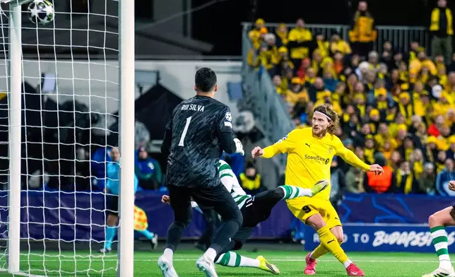 Bodo/Glimt's Kasper Hogh, right, scores their side's third goal of the game during the Champions League soccer match between Bodo/Glimt and Sporting Lisbon, in Bodo, Norway, Wednesday March 11, 2026. (Fredrik Varfjell/NTB Scanpix via AP)
