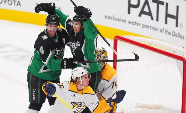 Dallas Stars left wing Jason Robertson (21) celebrates his goal with teammate defenseman Miro Heiskanen (4) in front of Nashville Predators goaltender Juuse Saros (74) and left wing Erik Haula (56) during overtime in an NHL hockey game Saturday, Feb. 28, 2026, in Dallas. (AP Photo/LM Otero)