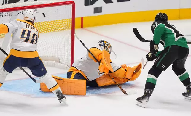Dallas Stars right wing Nathan Bastian (11) scores a goal against Nashville Predators goaltender Juuse Saros (74) and defenseman Nick Perbix (48) during the third period of an NHL hockey game Saturday, Feb. 28, 2026, in Dallas. (AP Photo/LM Otero)