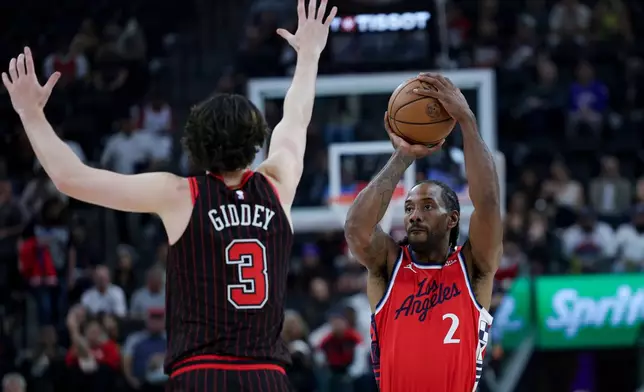 Los Angeles Clippers forward Kawhi Leonard, right, looks to shoot against Chicago Bulls guard Josh Giddey, left, during the first half of an NBA basketball game Friday, March 13, 2026, in Inglewood, Calif. (AP Photo/Ryan Sun)