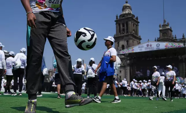People practice soccer skills in an attempt to set a Guinness World Record for the "largest soccer class" at the Zocalo in Mexico City, Sunday, March 15, 2026. (AP Photo/Marco Ugarte)