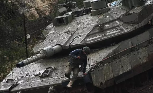 An Israeli soldier jumps from a tank in northern Israel near the border with Lebanon, Saturday, March 21, 2026. (AP Photo/Ariel Schalit)