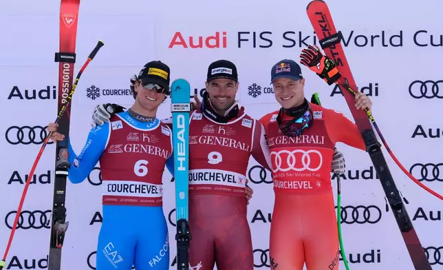 Austria's Vincent Kriechmayr, center, winner of an alpine ski, men's World Cup downhill race, celebrates on the podium with second-placed Italy's Giovanni Franzoni, left, and third-placed Switzerland's Marco Odermatt, in Courchevel, France, Friday, March 13, 2026. (AP Photo/Giovanni Auletta)