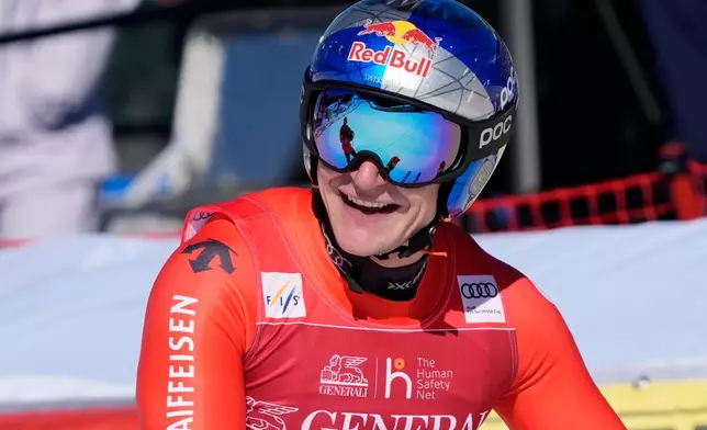 Switzerland's Marco Odermatt reacts at the finish area of an alpine ski, men's World Cup downhill race, in Courchevel, France, Friday, March 13, 2026. (AP Photo/Giovanni Auletta)